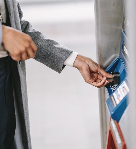 Woman holding a card and using an ATM